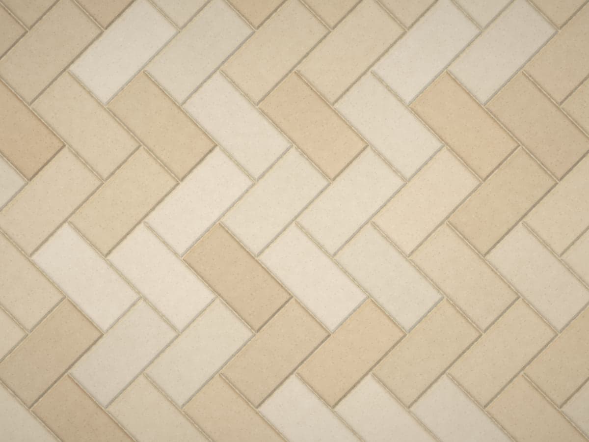 Tan concrete pavers in a 45-degree herringbone pattern.